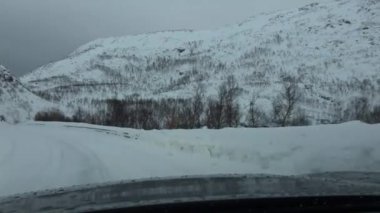 Aralık ayında Tromsoe, Norveç 'ten Grotfjord' a Kvaloya Adası 'nın kışlık yollarında araba sürmek.