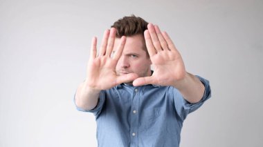 Avrupalı genç adam elleriyle dur işareti gösteriyor. Stüdyo çekimi