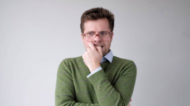 Avrupalı genç bir adam gergin ve tırnaklarını yiyor. Stüdyo çekimi