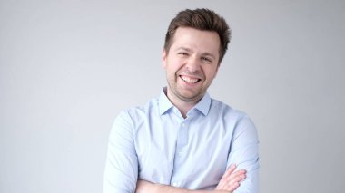 Genç Avrupalı adam kendinden emin bir şekilde kameraya bakar ve gülümser. Stüdyo çekimi