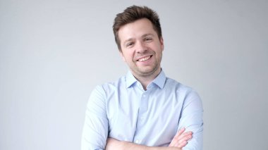 Genç Avrupalı adam kendinden emin bir şekilde kameraya bakar ve gülümser. Stüdyo çekimi