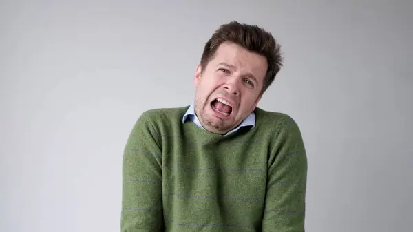 stock image The young European man is crying from a life failure. His girlfriend left him and he lost his job. Unstable mental state. Studio shot