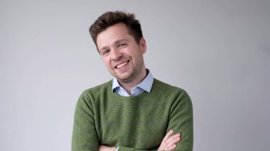 Genç Avrupalı adam kendinden emin bir şekilde kameraya bakar ve gülümser. Stüdyo çekimi