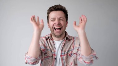 European young man is laughing loudly. Studio shot clipart