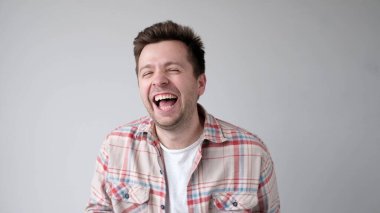 Avrupalı genç adam yüksek sesle gülüyor. Stüdyo çekimi