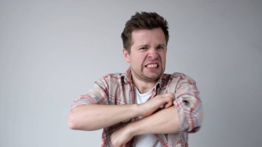 Avrupalı genç adam gergin bir şekilde ellerini kaşır. Alerjisi var ve kaşıntısı onu rahatsız ediyor. Stüdyo çekimi