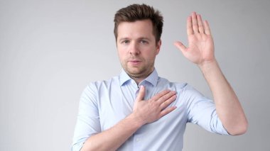 The European young man takes an oath to speak only the truth. Studio shot clipart