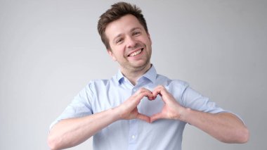 Avrupalı genç bir adam bir kalp işareti gösterir ve aşkını itiraf eder. Stüdyo çekimi