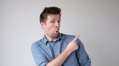 Avrupalı genç adam işaret parmağıyla reklamınız için boş bir yere işaret ediyor.