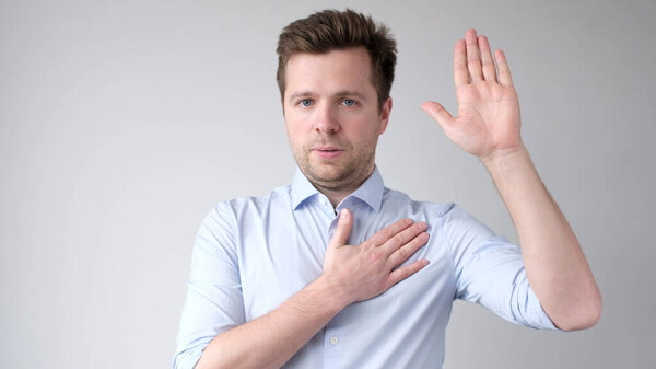 The European young man takes an oath to speak only the truth. Studio shot