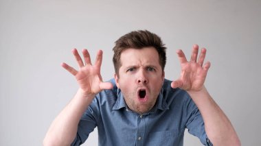 Genç adam müfettişi korkutur, böö der ve parmaklarını kıvırır..