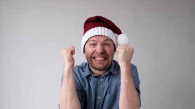 Yeni yıl şapkalı neşeli Avrupalı genç adam yeni yılı karşılamaktan mutluluk duyar. Yeni yıl aktiviteleri ve teklifleri için heyecanlı.