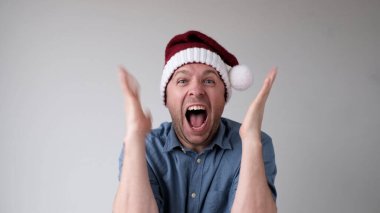 Yeni yıl şapkalı neşeli Avrupalı genç adam yeni yılı karşılamaktan mutluluk duyar. Yeni yıl aktiviteleri ve teklifleri için heyecanlı.