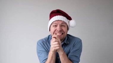 Yeni yıl şapkalı neşeli Avrupalı genç adam yeni yılı karşılamaktan mutluluk duyar. Yeni yıl aktiviteleri ve teklifleri için heyecanlı.