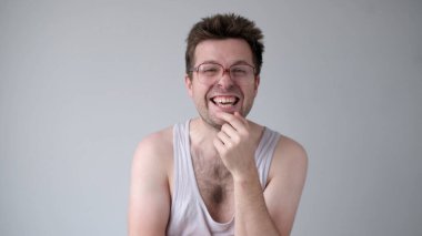 A sarcastic European man in big glasses mockingly laughs and points his finger at the camera clipart
