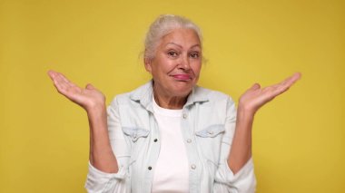 Elderly European woman shrugs her shoulders in confusion clipart