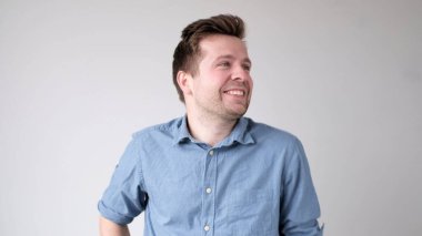 Genç Avrupalı adam kendinden emin bir şekilde kameraya bakar ve gülümser. Stüdyo çekimi