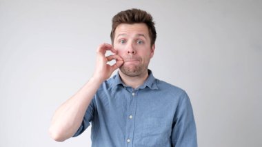 Genç adam bir sır saklamaya çalışıyor. O, konuşmak istemiyormuş. Stüdyo çekimi