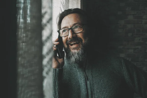 Щасливий Зрілий Чоловік Розмовляє Телефону Посміхається Розважається Вдома Біля Вікна — стокове фото