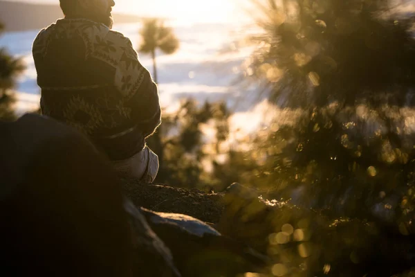 屋外レジャー活動の男は地面に座って夕日の景色を楽しむ時間をリラックスしています 山と屋外のハイキング旅行 日光で素晴らしい景色 自然と人とのつながり — ストック写真