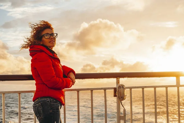 度假期间 旅游妇女在渡船码头享受温暖的橙色落日 在海上旅途愉快 背景为海浪和地平线 旅程历险 — 图库照片