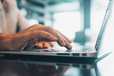 Close up view male hands writes on laptop. Entrepreneur man sit at desk work on modern wireless notebook, do remote telecommute, search information on internet, professional application