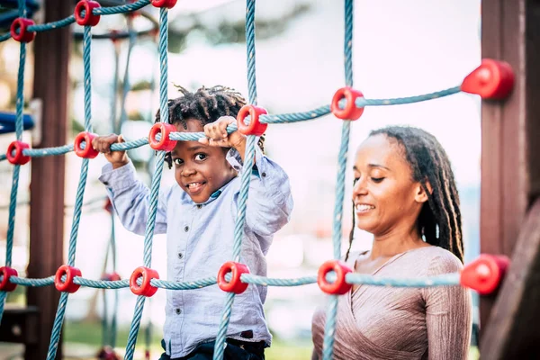 アフリカ系アメリカ人の家族の母親と息子が楽しい遊び場公園で一緒に時間を楽しんでいます 外でママと子供の笑顔 — ストック写真
