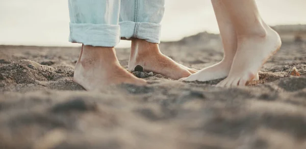 Couple feet kissing and loving concept. Outdoor leisure activity. Relationship, boy and girl in summer at the beach. People enjoying sand and nature. Barefoot man and woman unrecognizable. Romance
