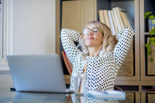 Healthy office lifestyle people concept.  satisfied businesswoman stretching arms under her head and smile after finish the day of work at home office. Concept of success and relax