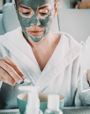 Günlük güzellik maskesi takan kadın portresi. Yüzüne yeşil çamur sürerek cilt sağlığı için doğal krem sürmüş. Güzel, olgun bir bayanın tedavi kullanması kavramı