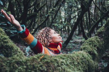 Kadın doğa yaşam tarzını ve açık hava aktivitesini kutluyor tek başına kollarını açıyor ve orman yeşil ormanlarında ağaçlara bakıyor. İç hayat, kadın yaşam tarzını dengeler.