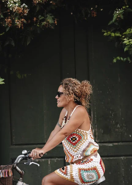 Arka Planda Yeşil Kapılı Bisiklet Süren Bir Kadının Dikey Görüntüsü — Stok fotoğraf