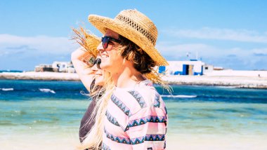 Arka planda tropik güzel plajları ve mavi okyanus suyu olan iki genç turist. Kız ve erkek arkadaş olarak yaz tatilinin tadını çıkarıyorlar. Açık havada güneşli bir hayat