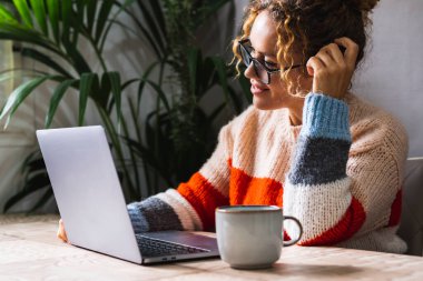 İş ya da eğlence için konferansta dizüstü bilgisayara gülümseyen mutlu kadın. İnternetteki aktiviteleri kullanarak. Ofis işyerindeki masada bilgisayar kullanan modern kadınlar. Ofis