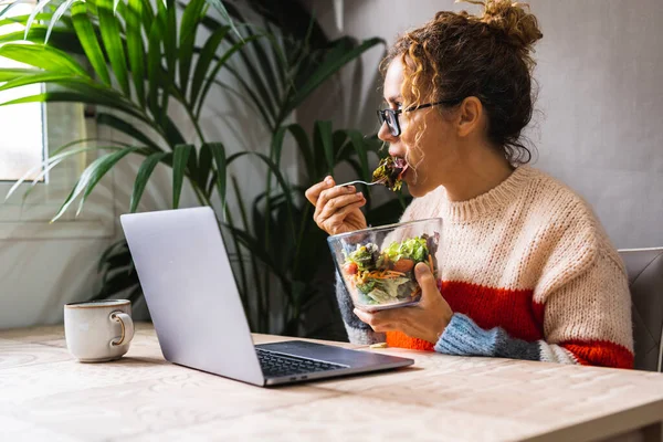 現代の起業家新しいビジネスコンセプトライフスタイルは 忙しいランチ休憩時間に仕事中に食べる ラップトップを使用している女性と透明なボウルからサラダを食べる 起業家健康食品ライフスタイル — ストック写真