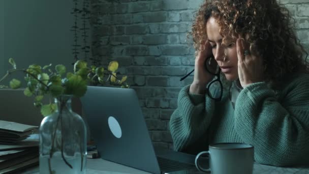 累了的女人在家里的电脑前 超负荷使用笔记本电脑的概念 女性在使用笔记本时睡在桌子上 心神不宁的成熟女士和网上活动 — 图库视频影像