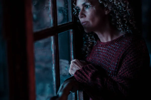 Evde Karanlıkta Endişeli Bir Ifadeyle Pencereden Dışarı Bakan Bir Kadının — Stok fotoğraf