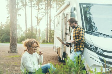 Alternatif yaşam tarzı modern yetişkin çiftler vanlife bayılıyor ve karavanla doğada geziyorlar ve internet bağlantıları geziniyorlar.. 