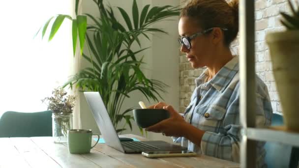 Dorosła Kobieta Domu Pracująca Laptopie Przy Stole Jedząca Zdrową Sałatkę — Wideo stockowe