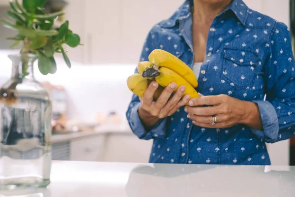 关在厨房里的女人抱着香蕉 过着真实的生活 健康的营养食品和女性 — 图库照片