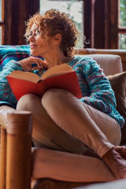Öğleden sonra evde dinlenen ve boş vakit geçiren insanlar. Kadın kitap okuyor sandalyede rahat rahat oturuyor ve dışarı bakıyor düşünüyor ve bekliyor. İnsanlar içeride yalnız zaman geçirmenin keyfini çıkarıyorlar.