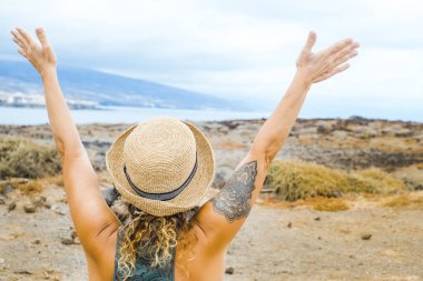 Turist kadının kollarını kaldırması ve varış noktasının keyfini çıkarması. Seyahat eden insanların yaşam tarzları. Macera yolculuğu kadın insanlar mutlu ve mutlu. Açık hava aktivitesi yapan insanlar. Kıyı ve gökyüzü