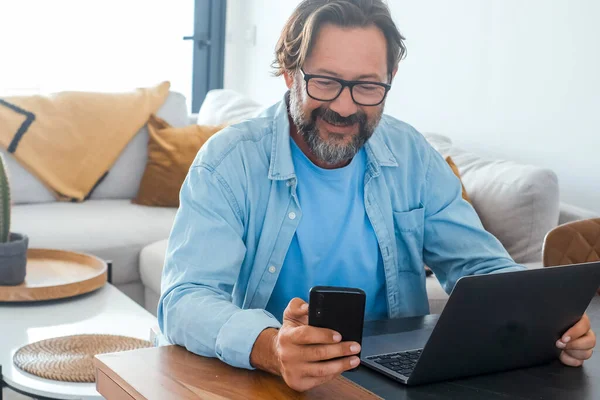 Man Thuis Met Behulp Van Mobiele Telefoon Laptop Tafel Concept — Stockfoto