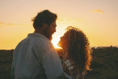 Romantik çift, açık havada turuncu, harika bir gün batımına karşı birbirlerine sevgiyle bakıyor. Romantizm ve ilişki erkek ve kadın insanlar birlikte tatilin tadını çıkarıyorlar. Boş zaman aktivitesi.