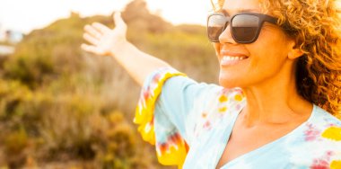 Portrait of happy cheerful woman in outdoor leisure activity alone smiling and enjoying freedom in sunset light time. Travel people. Healthy lifestyle and nature. Adult female happy and free person clipart