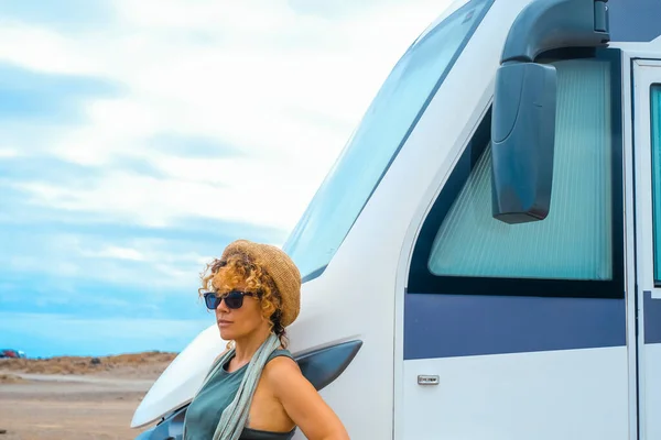 solo alone woman traveler look outside her modern big camper van motorhome. Concept of living adventure. Nomadic travel lifestyle. Vanlife. Female driver of big vehicle. Scenic independent lady