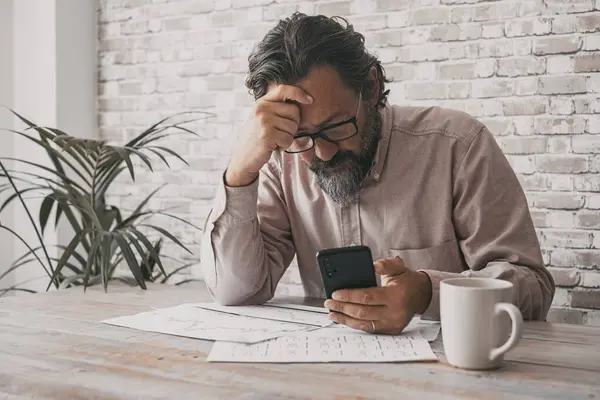 Człowiek Biurze Używający Telefonu Komórkowego Niepokojącym Wyrazem Twarzy Myślami Dotykającymi — Zdjęcie stockowe