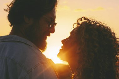 Birbirine aşık çiftler, boş zamanlarında birlikte güzel bir gün batımının keyfini çıkarırlar. Gözlerine bakar ve gülümserler. Mutluluk, erkek ve kadın randevusu. Tatil hayatı süren insanlar