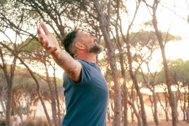 Özgürlüğü ve doğası olan bir adam konsept hayatı sever. Ağaçlara sarılmak için kollarını açar. Gün batımı güneş ışığı. İnsanlar ve çevre. İklim değişikliği dünyayı kurtarır. Seyahat güzergahı. # Dışarıda boş vakit geçirmek #