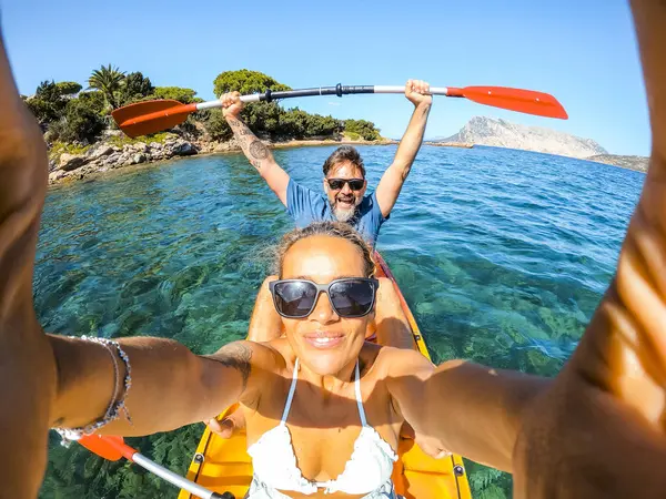 青いきれいな海の水と背景の海岸線を持つカヤックのカヌーの中のセルフィー写真を撮る慎重な大人の観光客の男と女性のカップルをお楽しみください 旅行と夏休みについて — ストック写真